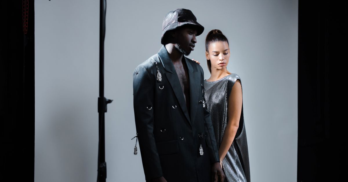 A diverse fashion photoshoot featuring models in a studio with dramatic lighting.